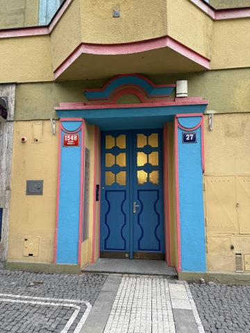 Detail modrých dřevěných dveří s rondokubistickým zdobením na Žižkově