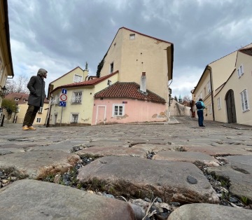 Barevný soubor tří historických domků s průjezdem v pražské čtvrti Nový Svět